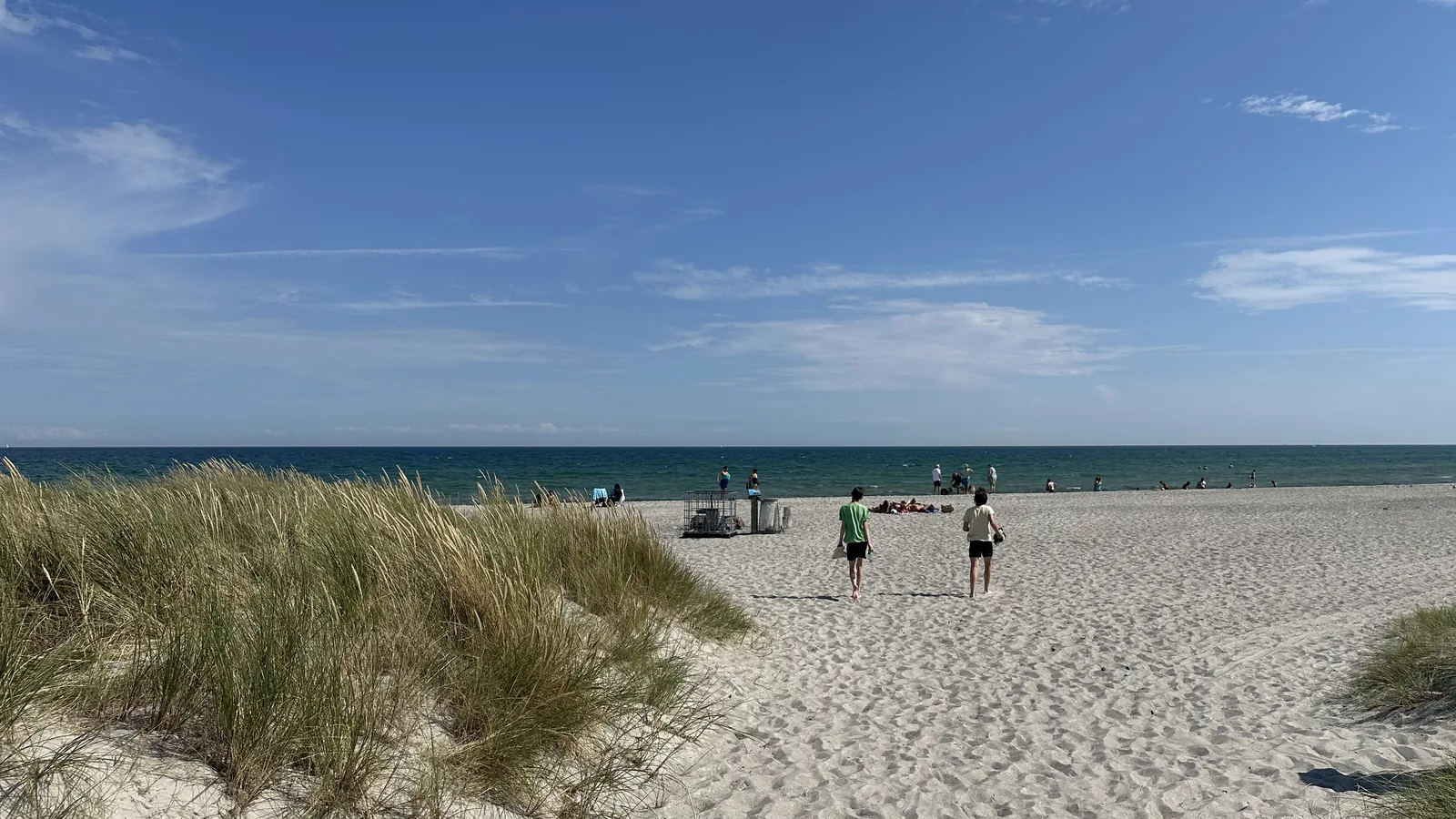 Two teenagers walking through the dunes toward the beach near Grenaa
